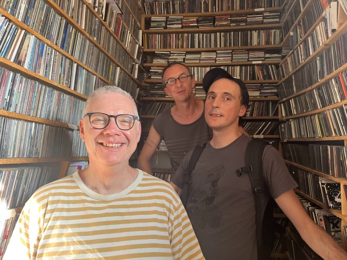 Loïc, casquette vissée sur la tête, aux côtés d’un bénévole et d’un salarié : tous trois utilisent encore des milliers de CD et de cassettes diffusés à l’antenne. © Loïc Couatarmanach. Loïc, casquette vissée sur la tête, aux côtés d’un bénévole et d’un salarié : tous trois utilisent encore des milliers de CD et de cassettes diffusés à l’antenne. © Loïc Couatarmanach.